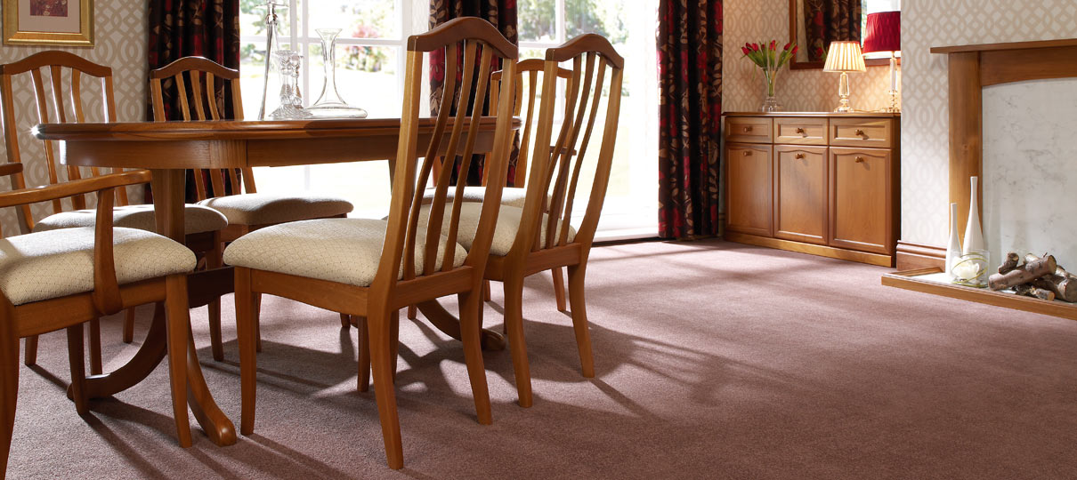 Mauve-brown carpet in a dining room set with an oak table, chairs and sideboard.